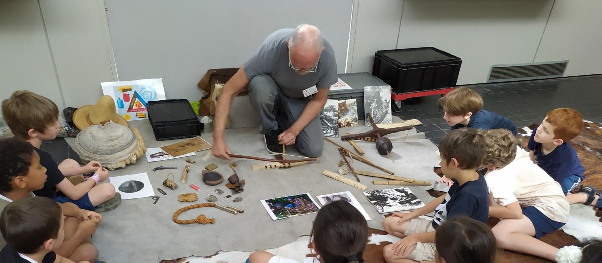 démonstration des techniques préhistoriques d'allumage du feu devant des enfants