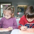 Photographie de deux enfants participant à une animation consacrée à la gravure préhistorique