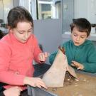 Animation pédagogique consacrée à l'habitat préhistorique. Ici, construction d'une maquette de tente en bois et peau d'animal