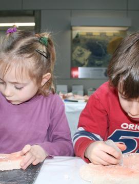 Photographie de deux enfants participant à une animation consacrée à la gravure préhistorique