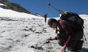 Photo d'une archéologue réalisant un prospection archéologique sur un glacier alpin