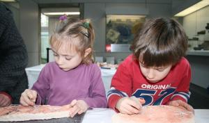 Photographie de deux enfants participant à une animation consacrée à la gravure préhistorique