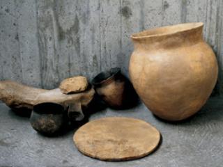 Meule en pierre et récipients en terre cuite.