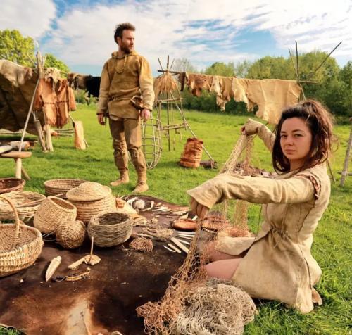 Photo d'un campement préhistorique reconstitué par des animateurs en archéologie