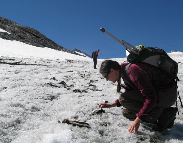 Photo d'une archéologue réalisant un prospection archéologique sur un glacier alpin