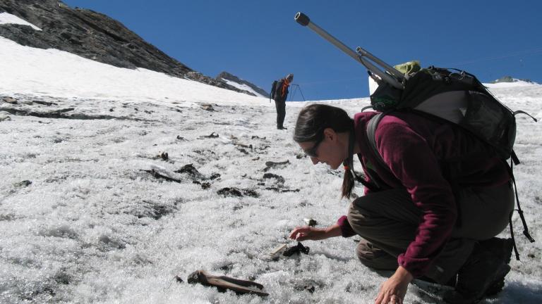 Photo d'une archéologue réalisant un prospection archéologique sur un glacier alpin