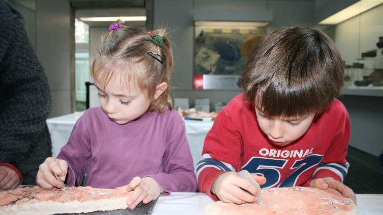 Photographie de deux enfants participant à une animation consacrée à la gravure préhistorique
