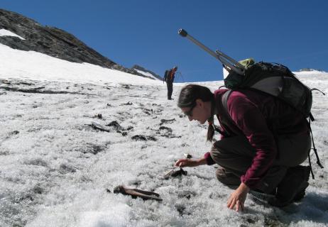 Photo d'une archéologue réalisant un prospection archéologique sur un glacier alpin